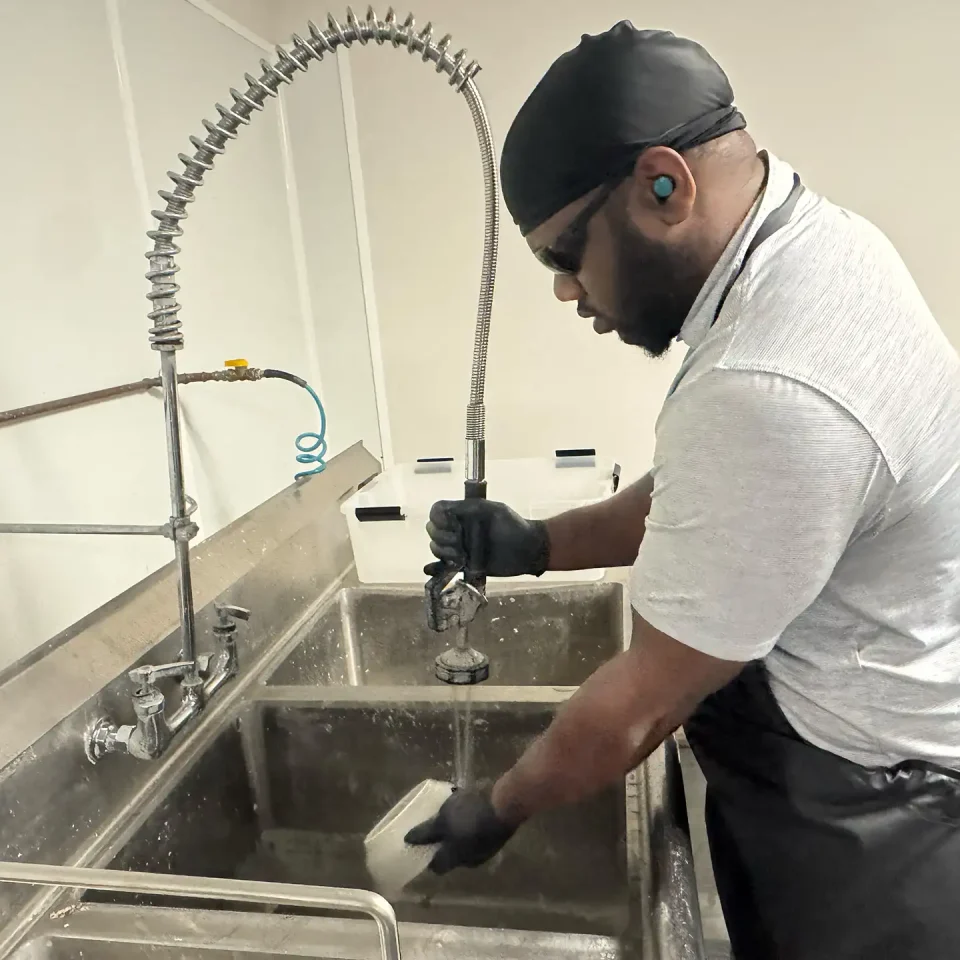 Contents Cleaning & Pack-Outs - Property Medics of Georgia A worker cleaning dishes