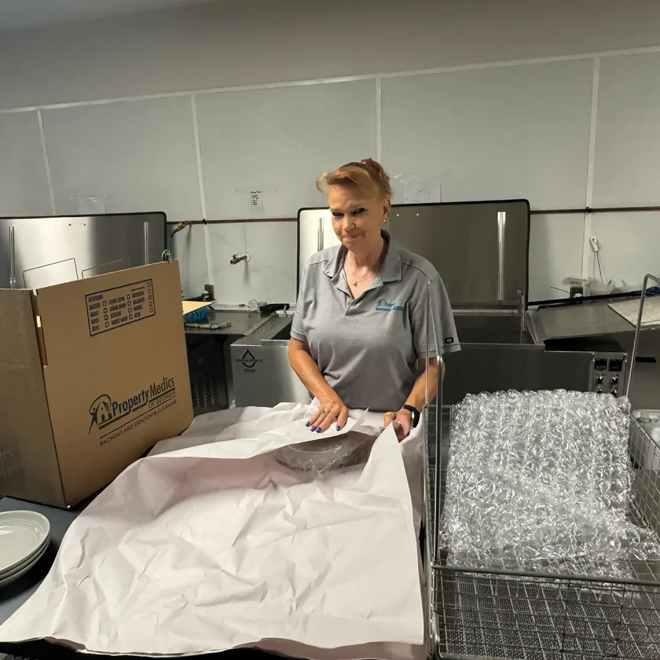 Contents Cleaning & Pack-Outs - Property Medics of Georgia A worker cleaning and packaging contents